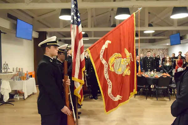 A line of students holding flags with the Marine Corp flag showing